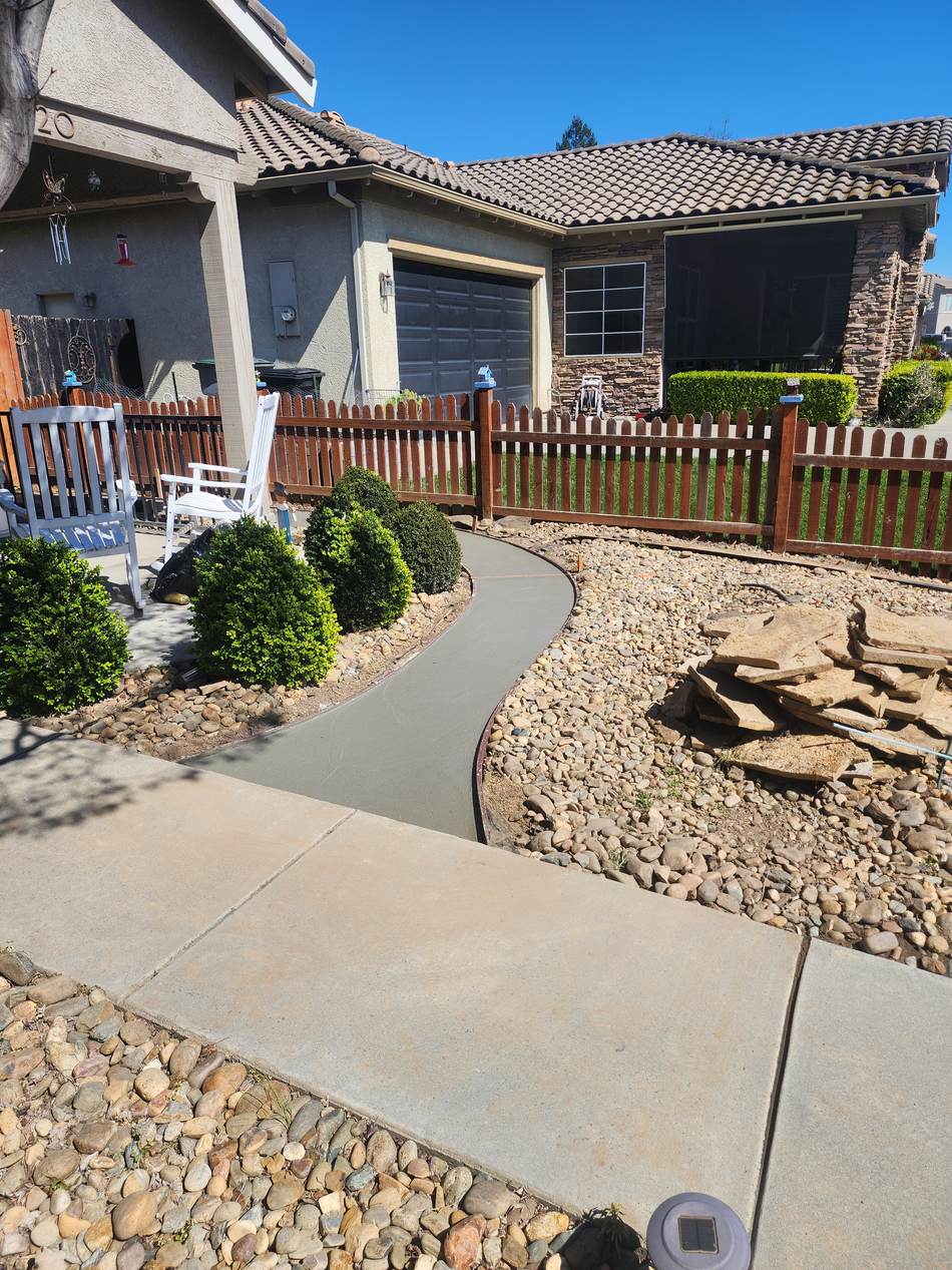 Curved concrete walkway before decorative paver inlays in Escalon